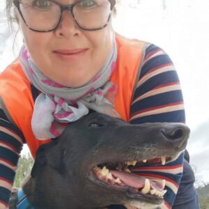 Greyhound cuddles volunteer dog walker